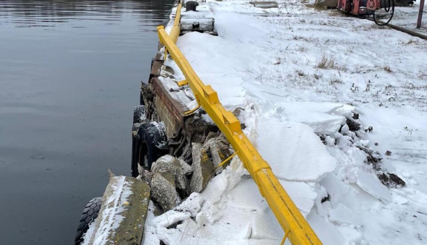 Bojāta piestātnes mala ar deformētu metāla apmali Rīgas brīvostā, Mangaļsalā
